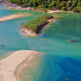 Aerial view of kayakers and a boat exploring a calm tidal inlet in Abel Tasman National Park