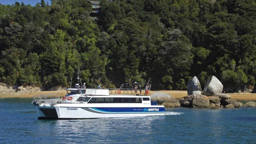 Abel Tasman Sea Shuttle boat passing Split Apple Rock on a sunny day