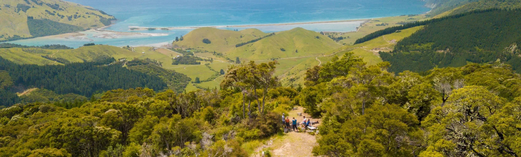 Aerial view of quad bikes parked at a lookout on the Bayview Circuit in Nelson, with riders taking in views of Cable Bay and the coastline.