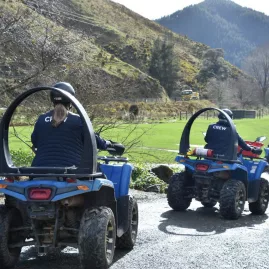 Guides lead a group ATV ride at Cable Bay Adventure Park’s Bayview Circuit with scenic hill views.