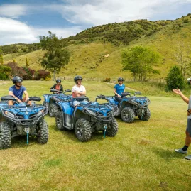 A guide giving a quad bike safety briefing to riders at the grassy base of the Bayview Circuit at Cable Bay Adventure Park, Nelson.