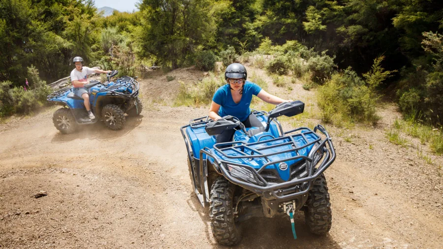 Two riders navigating a dusty forest trail on quad bikes at Cable Bay Adventure Park’s Bayview Circuit in Nelson.