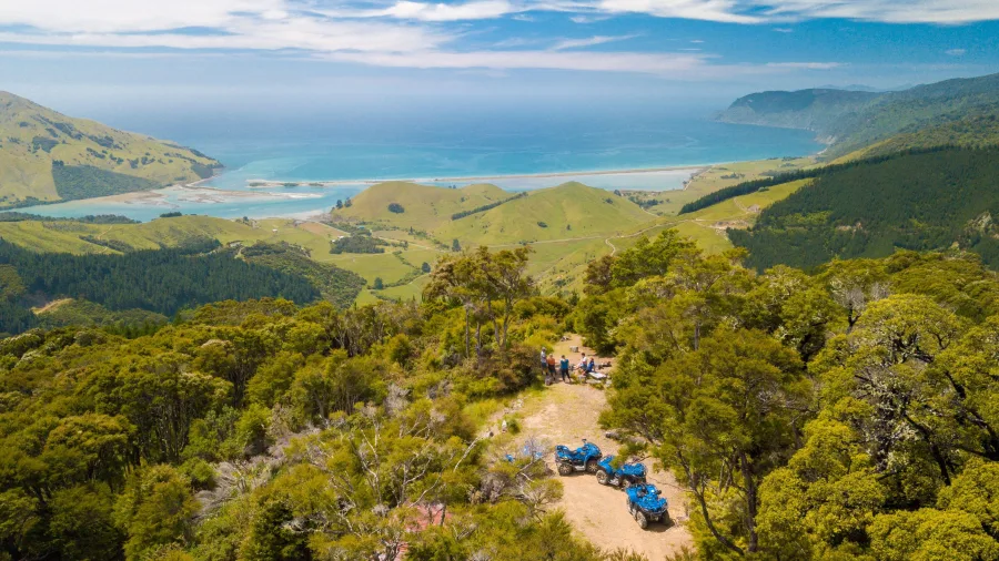 Aerial view of quad bikes parked at a lookout on the Bayview Circuit in Nelson, with riders taking in views of Cable Bay and the coastline.