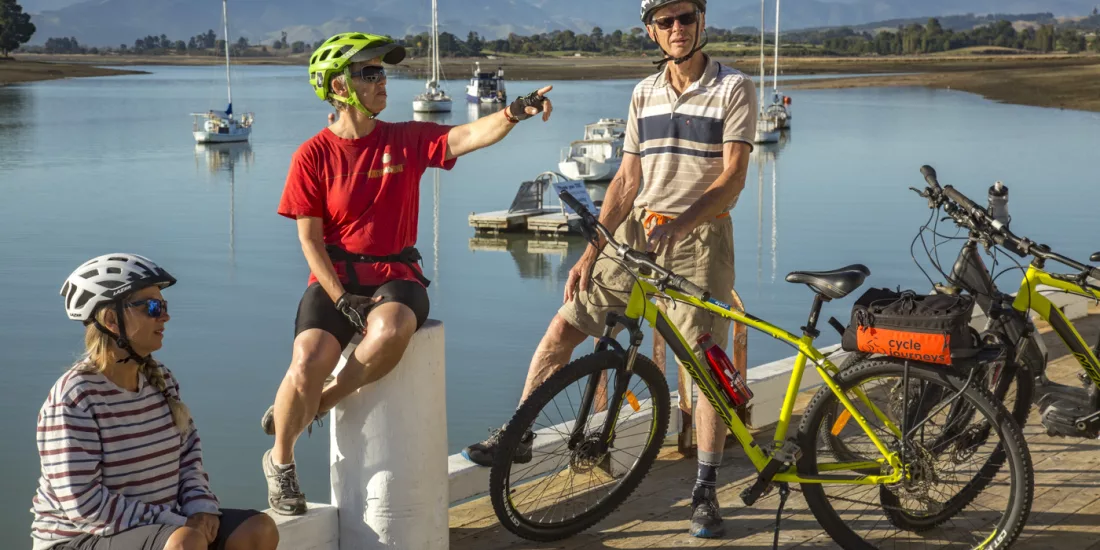 Cycling family relaxing by the waterfront on the Great Taste Trail