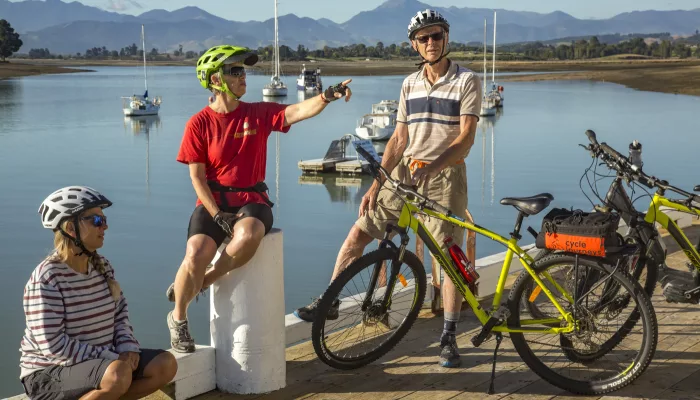 Cycling family relaxing by the waterfront on the Great Taste Trail