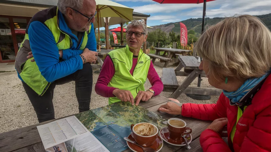 Cyclists planning their route over coffee at a cafe along the Great Taste Trail