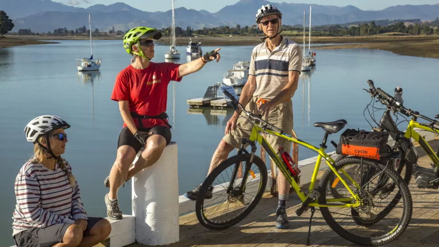 Cycling family relaxing by the waterfront on the Great Taste Trail