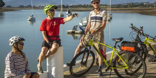 Cycling family relaxing by the waterfront on the Great Taste Trail