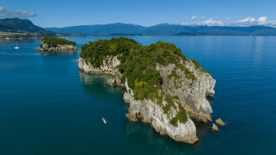 Aerial view of kayaker near dramatic rocky islands in Golden Bay, New Zealand