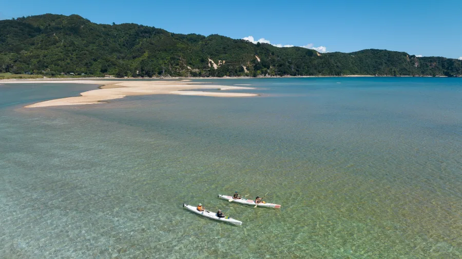 Aerial view of kayakers paddling near a tidal sandbar in Golden Bay