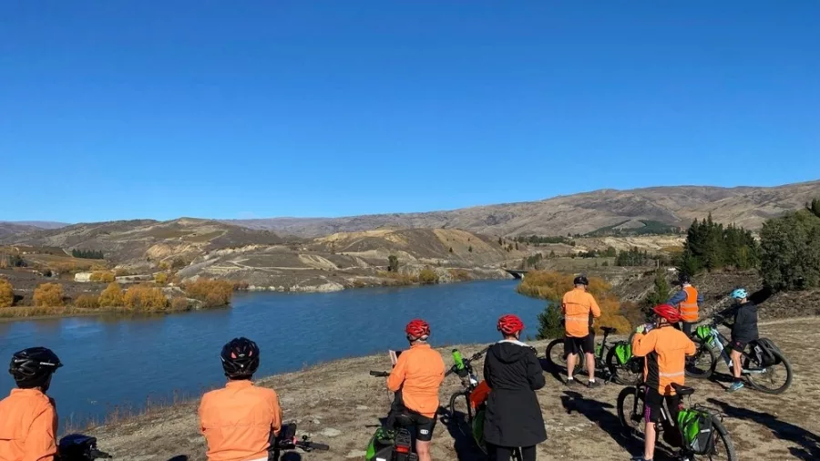 Cycling group overlooking the Bannockburn landscape and Kawarau River in Central Otago
