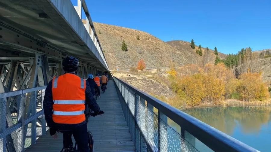 Cyclists crossing Bannockburn Bridge on a scenic trail in Central Otago