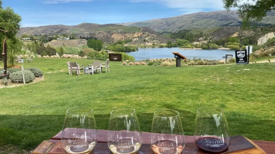 Carrick wine tasting flight overlooking Bannockburn vineyards and lake in Central Otago