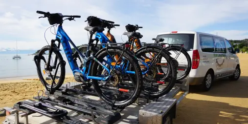Close-up of e-bikes loaded on Kiwi Journeys trailer at Kaiteriteri Beach