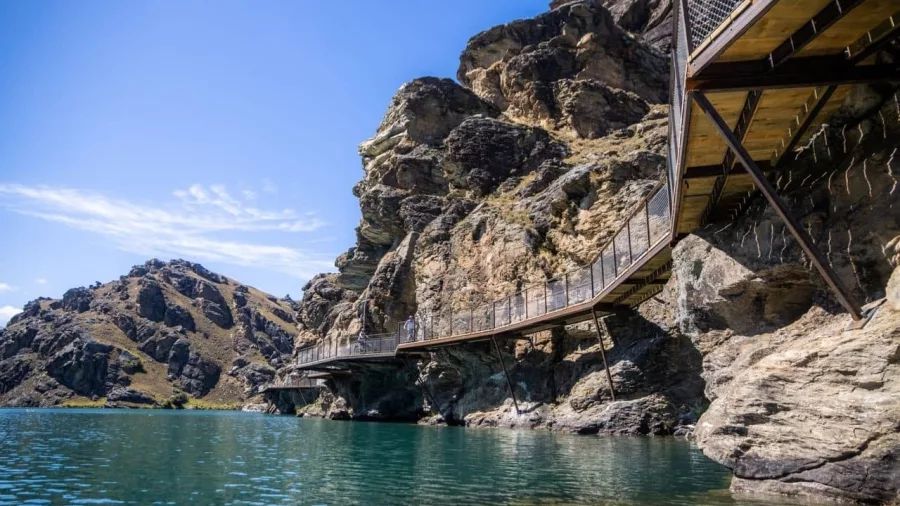 Cyclists cross the suspension boardwalk over Lake Dunstan in Central Otago