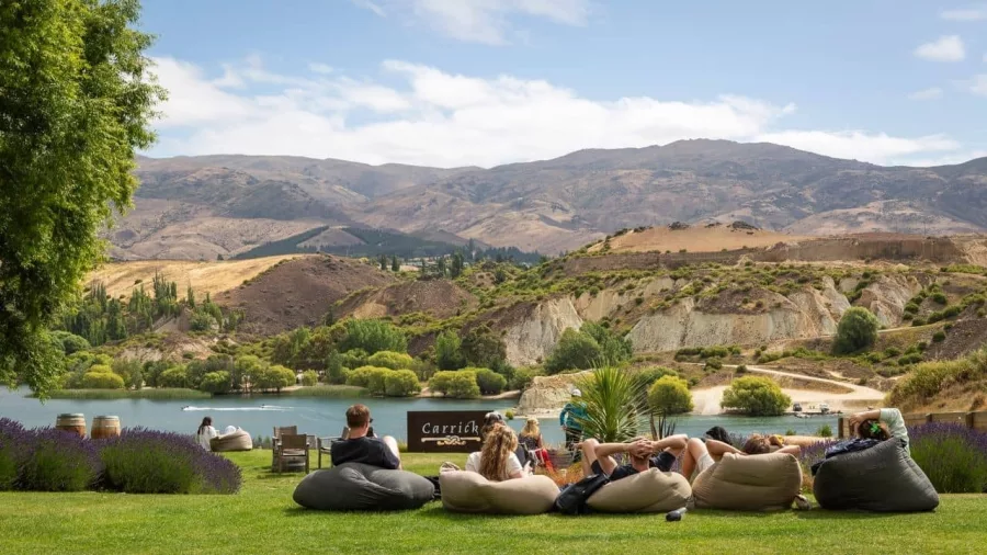 Visitors relax on bean bags overlooking Lake Dunstan and the mountains at Carrick Winery