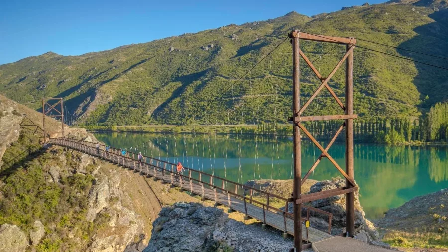 Cyclists cross the swing bridge on the Lake Dunstan Trail in Central Otago