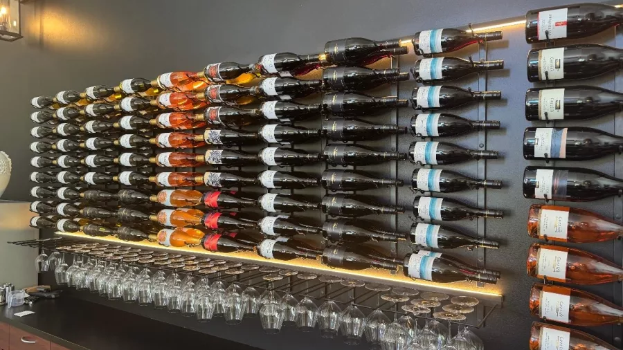Wall-mounted wine bottle display at a winery along the Lake Dunstan Trail in Central Otago