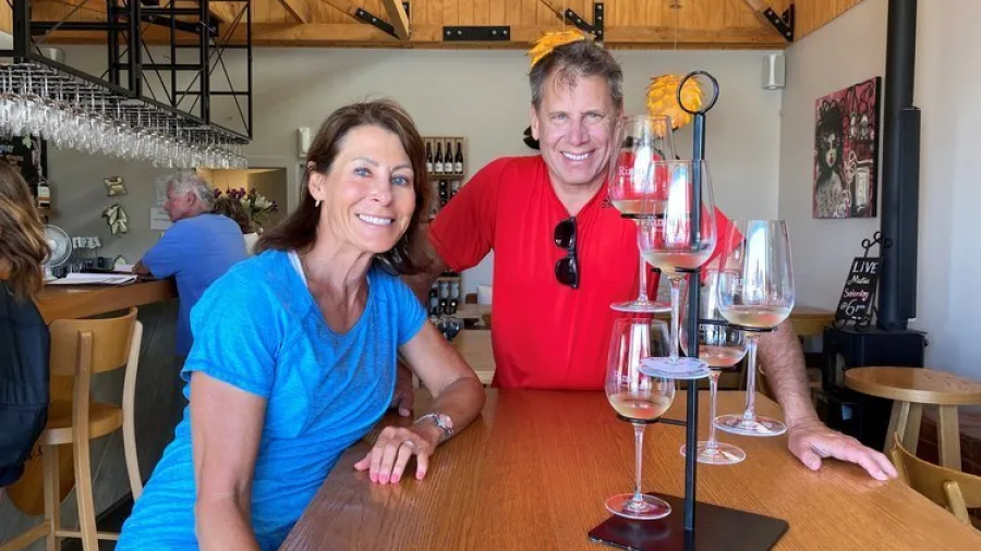 Smiling couple at a wine tasting table at Moutere Hills Winery in Nelson