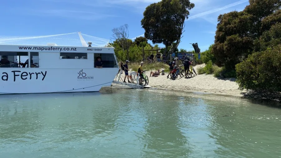 Cyclists boarding the Mapua Ferry with bikes on a sunny day