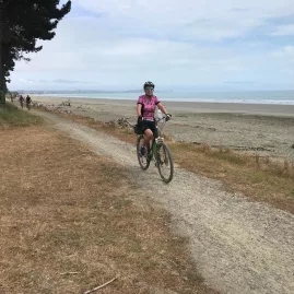 Cyclist riding along the beachside trail at Rabbit Island in Nelson
