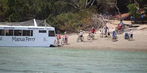 Cyclists boarding the Mapua Ferry with bikes along the Great Taste Trail in Nelson, New Zealand