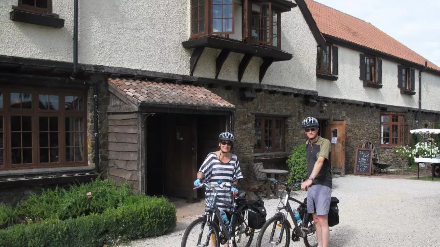Two cyclists with bikes outside character-style accommodation