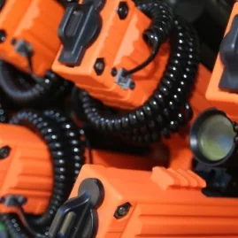 Close-up of orange laser tag guns and coiled cables used for outdoor battles at Pro Combat in Nelson