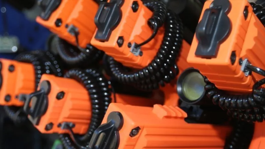 Close-up of orange laser tag guns and coiled cables used for outdoor battles at Pro Combat in Nelson