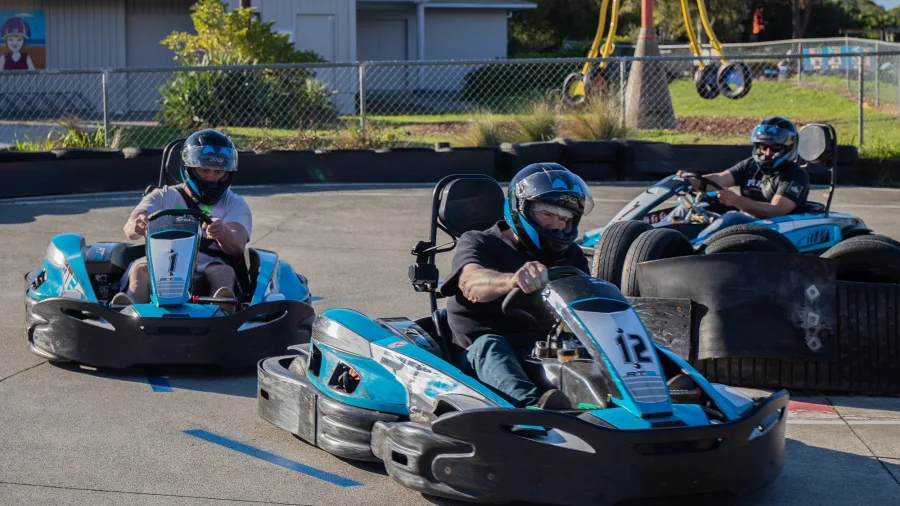 Three go kart drivers rounding a corner on the Pro Karts track in Nelson during a race