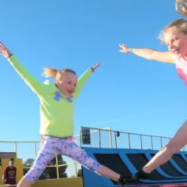 Two young girls jumping on outdoor trampolines at Pro Karts trampoline park in Nelson