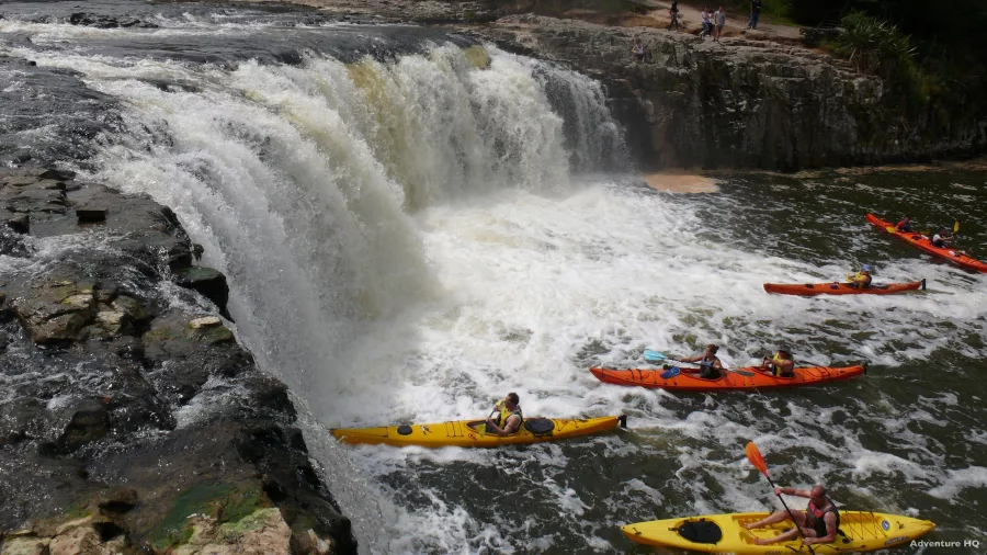 Group of kayakers paddling below Haruru Falls in the Bay of Islands