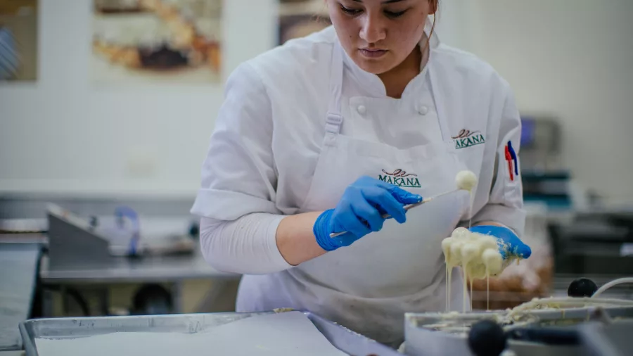 Chocolatier dipping truffles in white chocolate at Makana Boutique Chocolate Factory