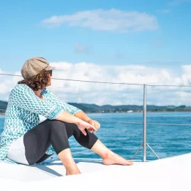 Woman relaxing on the deck of a private sailing charter in the Bay of Islands