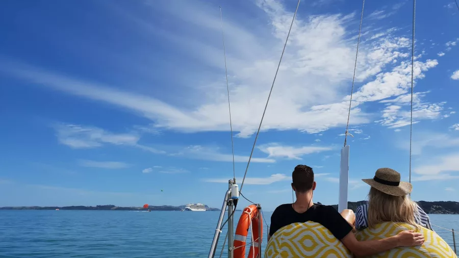 Couple relaxing on a catamaran during an evening cruise in the Bay of Islands