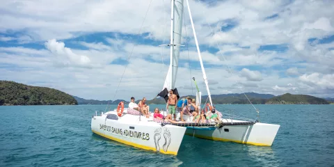 Group relaxing on a Barefoot Sailing Adventures catamaran in the Bay of Islands