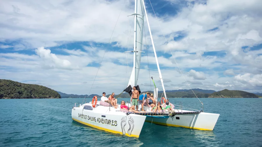 Group relaxing on a Barefoot Sailing Adventures catamaran in the Bay of Islands