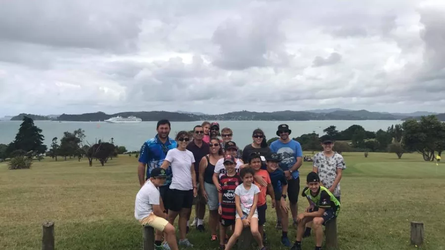 Group of people posing for a photo at Waitangi Lookout with cruise ship and harbour views in the background