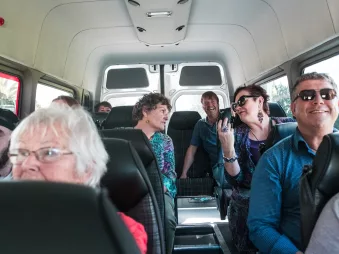 Passengers smiling and chatting inside a Bay of Islands Tours van during a shore excursion