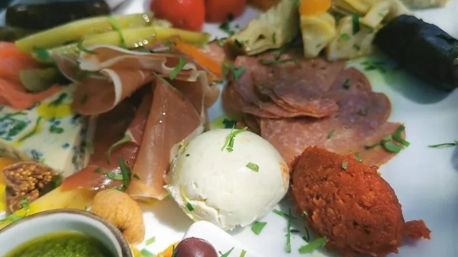 Close-up of a gourmet platter with meats, cheese, olives, and spreads from the Taste the Bay Foodie Tour