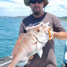 Angler holding a large snapper caught using a softbait in the Bay of Islands