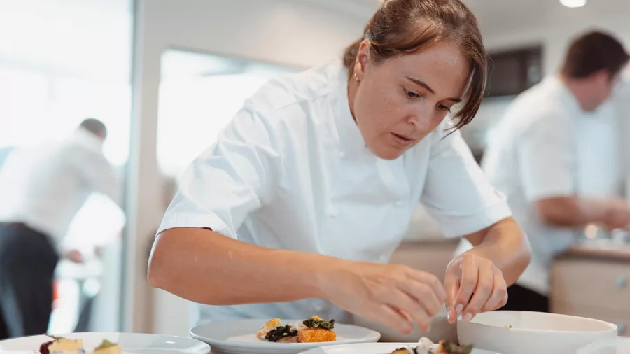 Chef plating gourmet meals in the galley of a luxury vessel