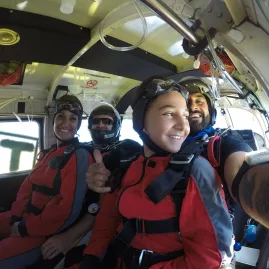 Tandem skydivers smiling inside plane before jumping over Bay of Islands
