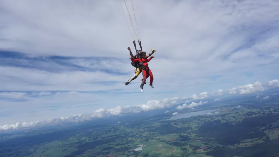 Tandem skydive over green landscapes with parachute open in Bay of Islands
