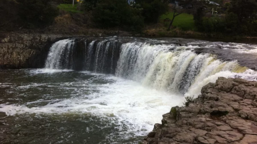 View of Haruru Falls cascading into a wide basin in the Bay of Islands