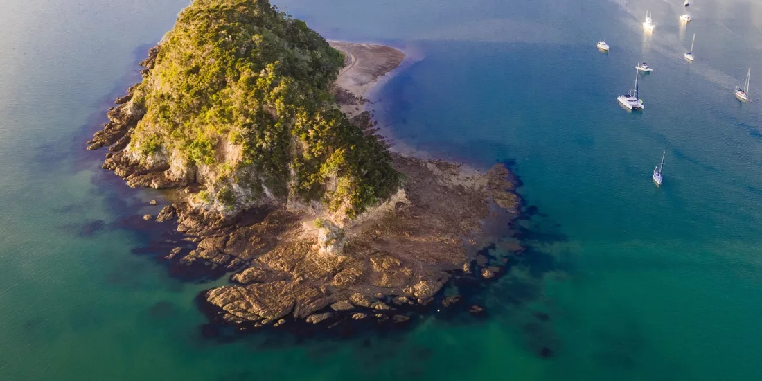 Aerial view of a small island and anchored yachts in the Bay of Islands, New Zealand