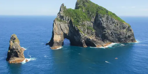 Motukōkako Island’s Hole in the Rock formation rising from the Pacific Ocean