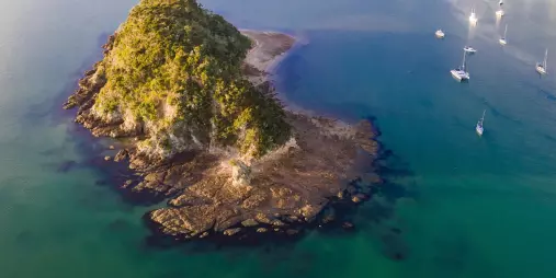 Aerial view of a small island and anchored yachts in the Bay of Islands, New Zealand