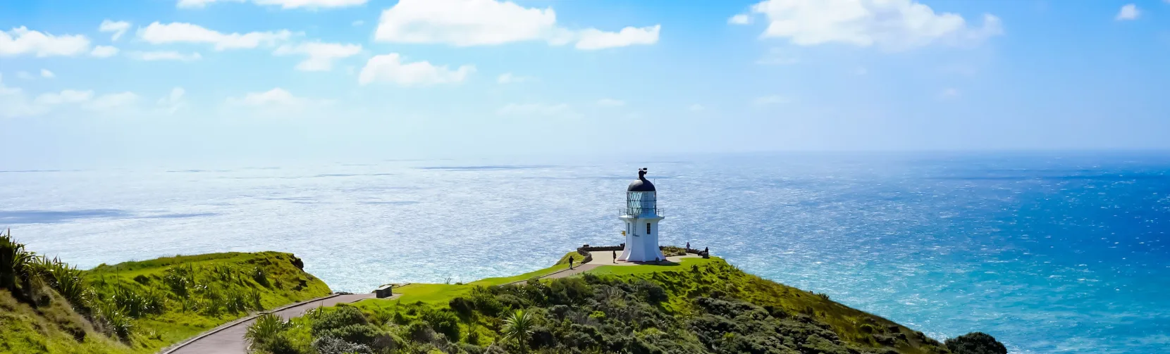 Winding pathway leading to Cape Reinga Lighthouse on a sunny day in Northland, New Zealand