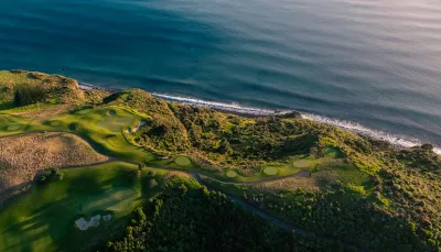 Golf greens at Kauri Cliffs Golf Course positioned along the shoreline in the Bay of Islands, New Zealand